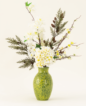 Het Zijden kunstbloemen boeket Earthlight is gearrangeerd in een vaas met groene structuur, met witte hortensia's, delicate witte bloesems en groenbruin gebladerte tegen een effen lichte achtergrond.