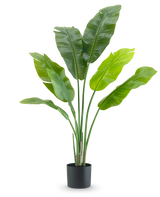 De Kunstplant Strelitzia Nicolai Deluxe 120 cm is een luxe kamerplant met grote, brede bladeren in een eenvoudige zwarte pot, stijlvol tegen een witte achtergrond.
