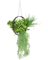De Kunst hangplant varen UV 30 cm in ring zwart is een hangende ronde metalen plantenbak met weelderig kunstgroen varenblad, slepende bladeren en een zilveren ketting, tegen een witte achtergrond.